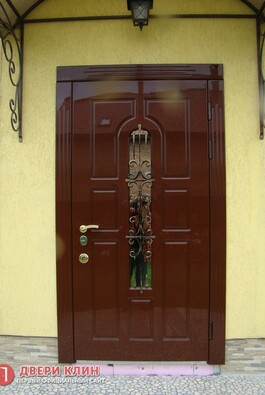 Элитная дверь для коттеджа со вставкой из стекла и ковки